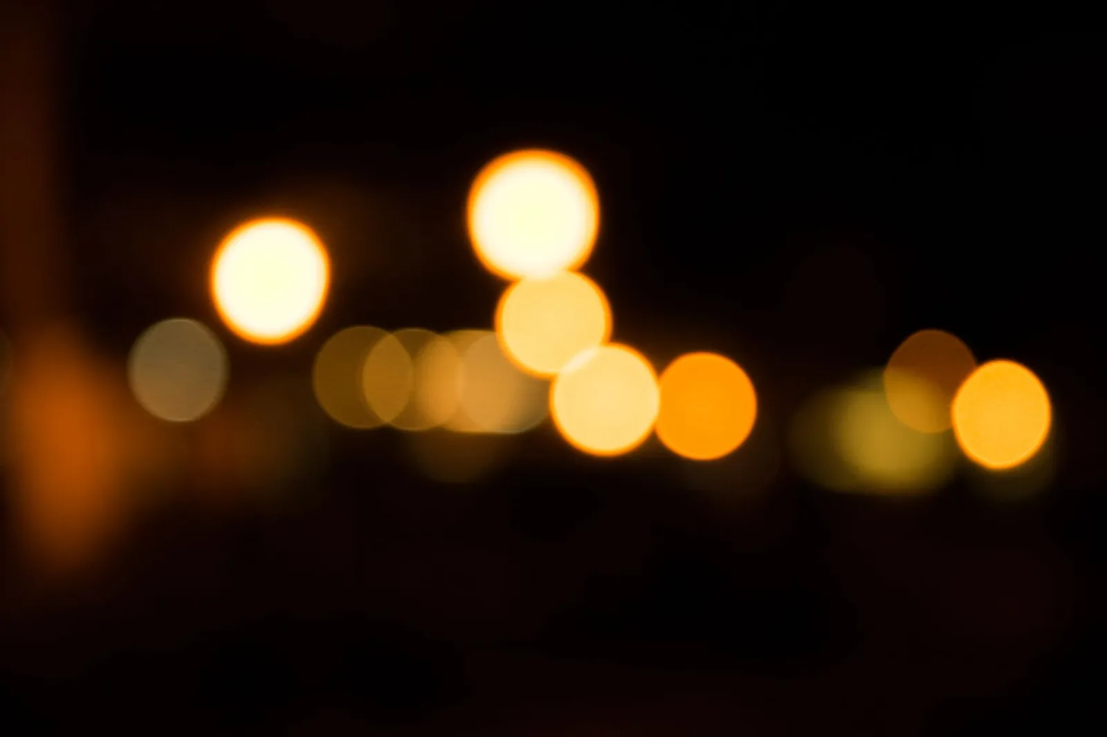 Warm gold points of light blurred against black, an abstract image about guidance